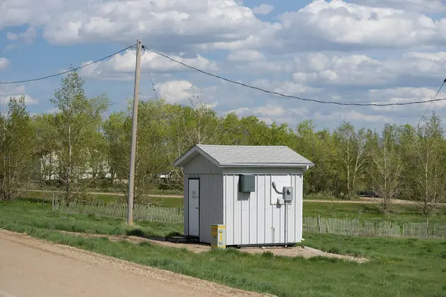 Small utility shed beside a gravel road